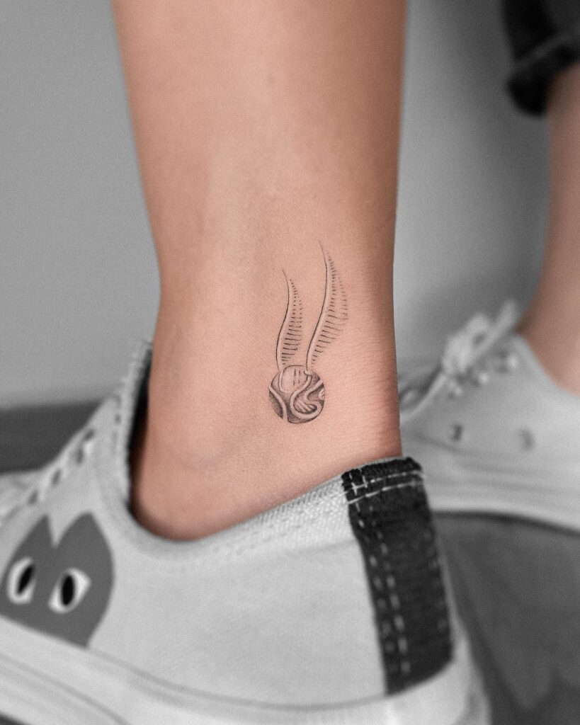 Chasing fantasy golden snitch tattoo above the ankle