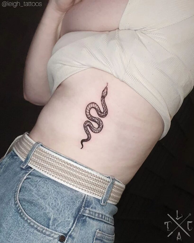 Clear-patterned snake tattoo on the rib with forked tongue and intricate details-snake charmer