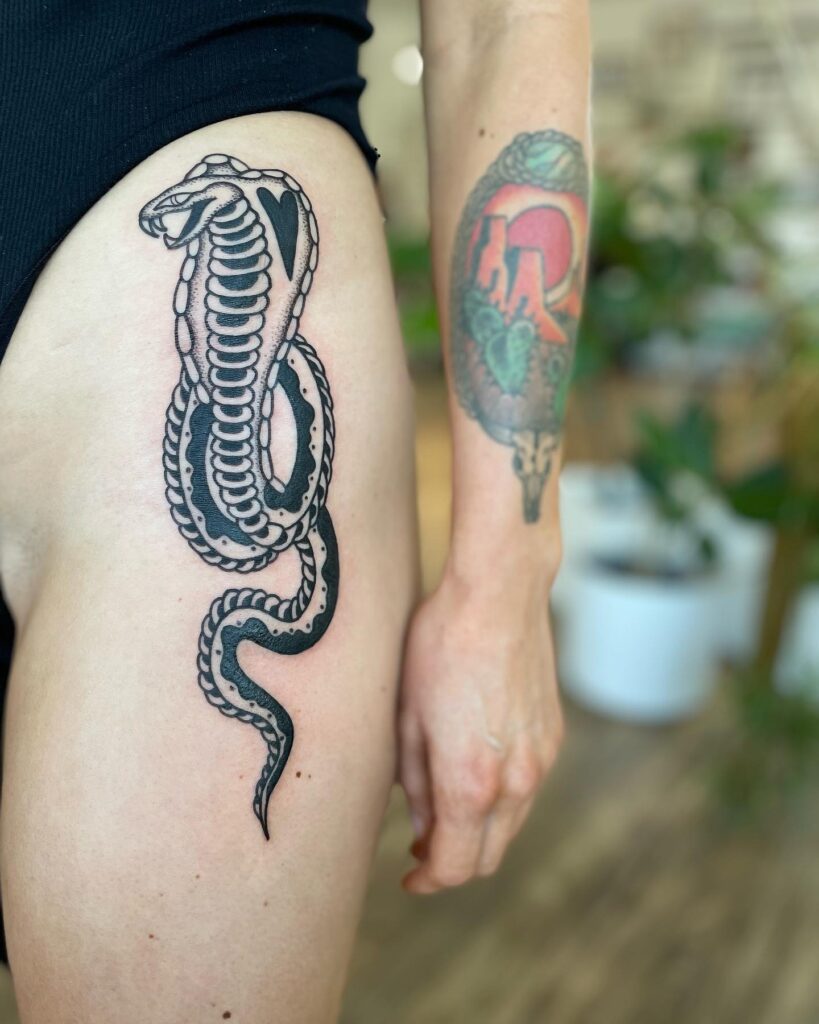 Cobra hip tattoo with intricate black and grey patterns, a graceful display: hip serpent