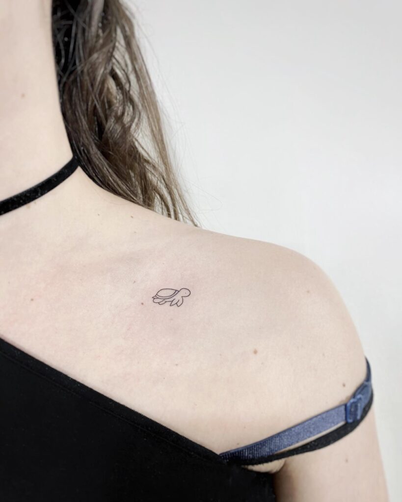 Collarbone tattoo with a side view perspective: tiny turtle silhouette