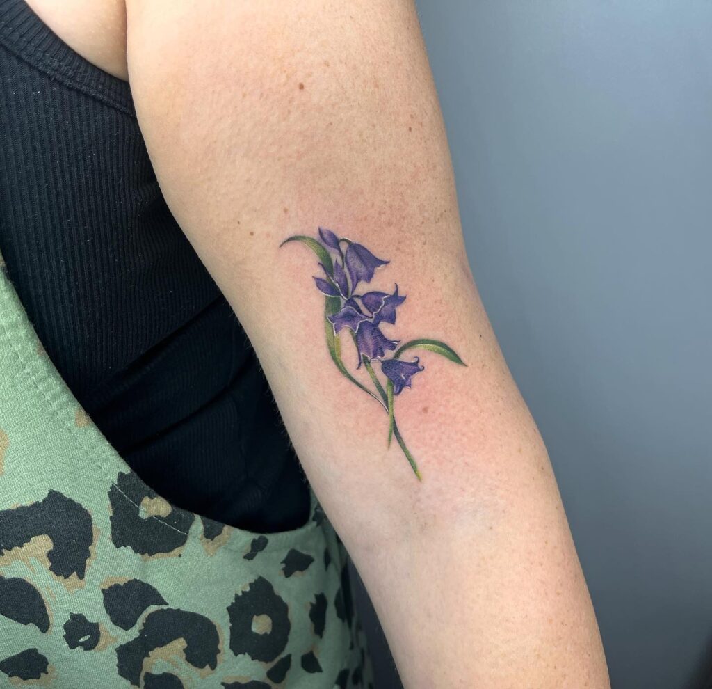 Colorful bluebell flower tattoo above the elbow for females