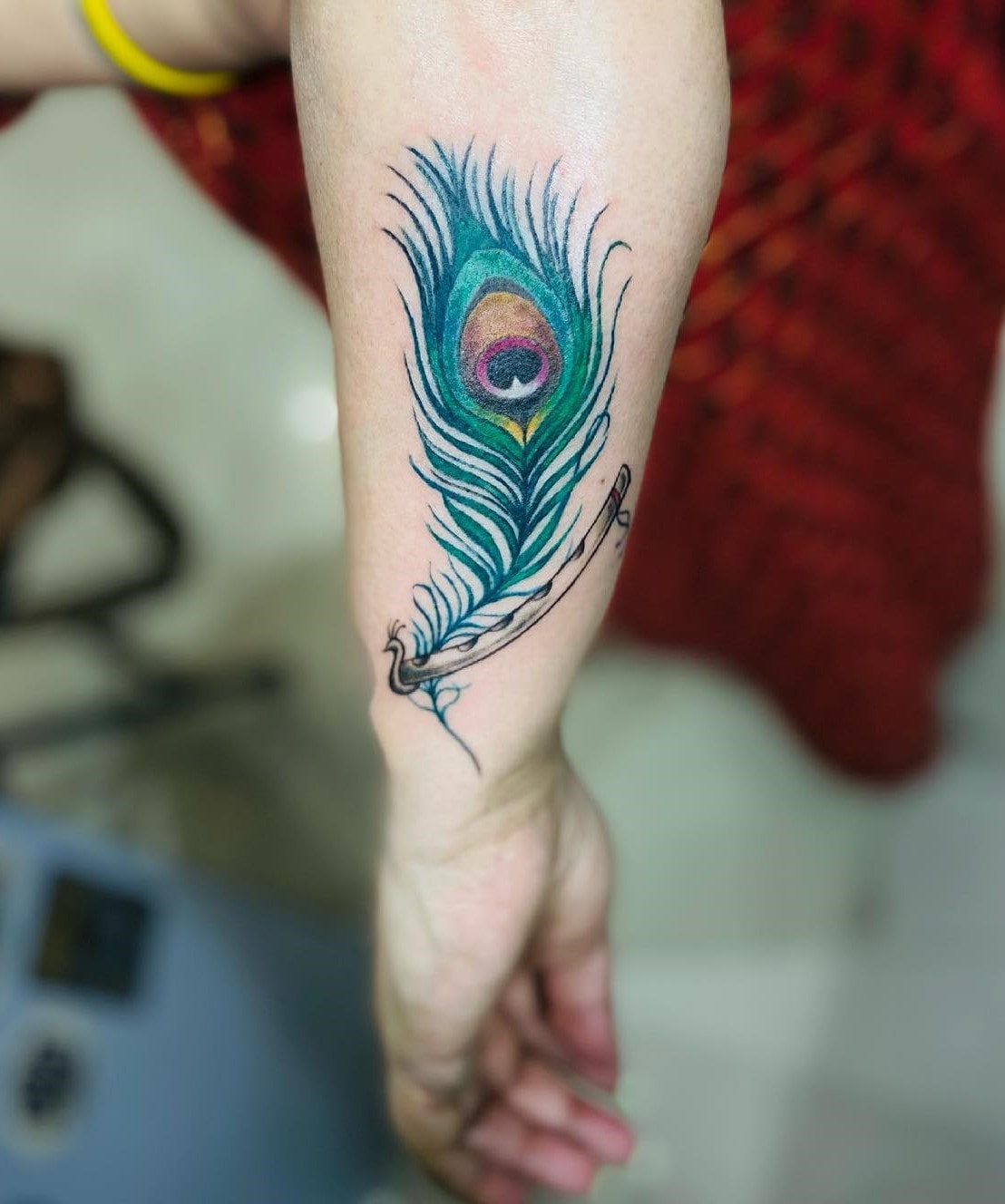 Colorful peacock feather tattoo on hand with image Colorful peacock feather tattoo on hand with image