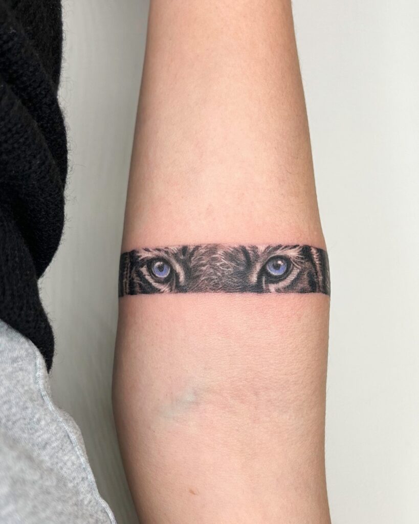 Colorful Tiger Eye Band Tattoo Encircling the Forearm: Radiant Gaze
