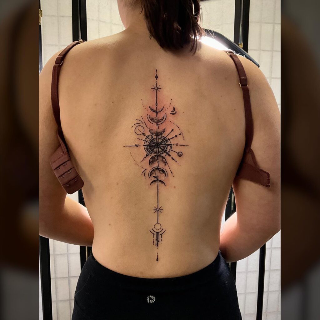 Compass and moon phases spine tattoo for a mystical touch: celestial guidance
