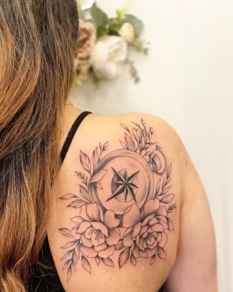 Compass surrounded by flowers on the back of the shoulder: floral orientation