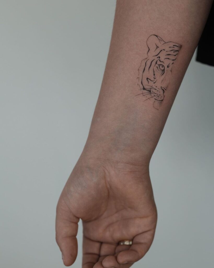 Cool fineline half face tiger tattoo on the wrist fierce feline ink