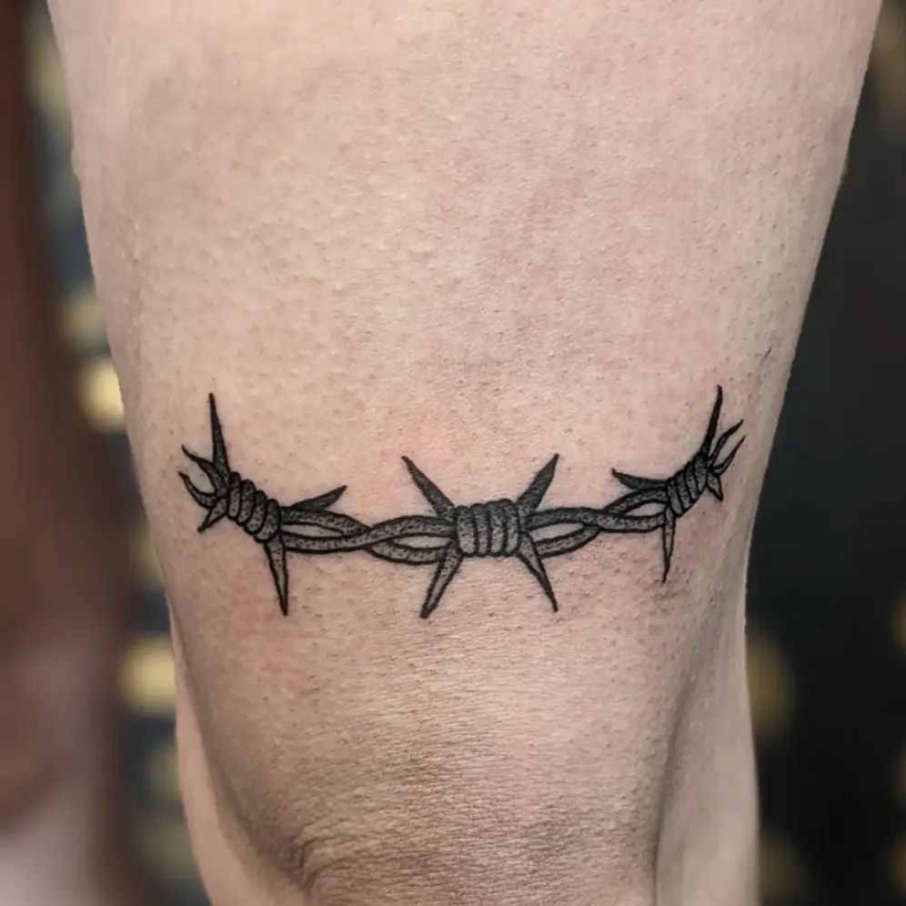 Creative Barbed Wire Tattoo Above the Knee: Edgy Ink Concept