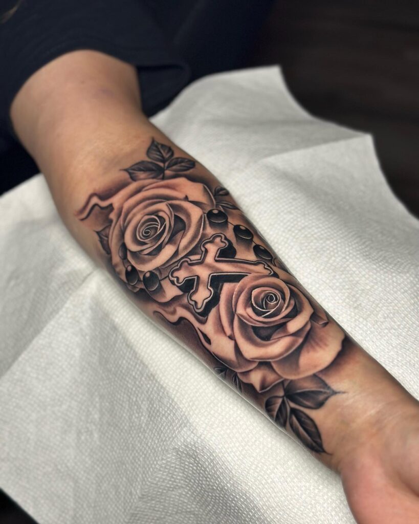 Creative gray inner forearm tattoo for men cross with roses - a unique and meaningful design
