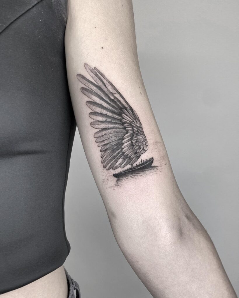 Creative Sailboat Tattoo on the Bicep, Wings Unfurling: Sailing on Wings