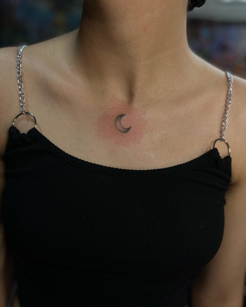 Crescent moon tattoo on the collarbone, gradient black and grey color for an ethereal look: moonlit dream