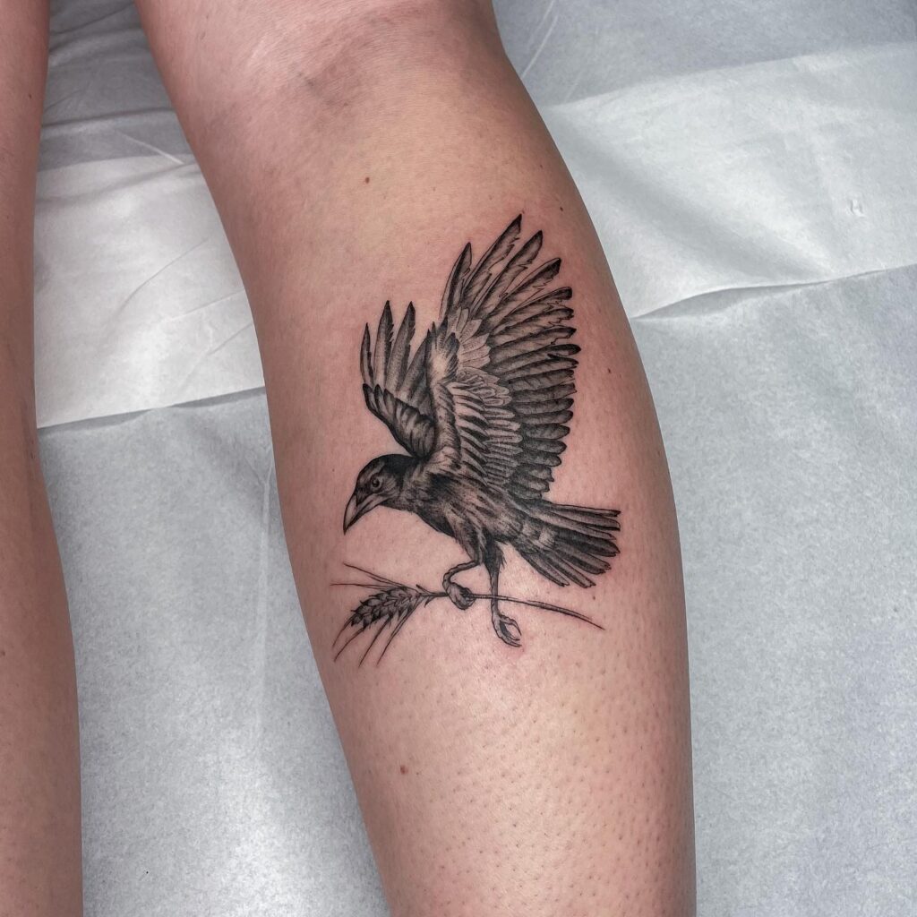 Crow Soaring with a Plant Tattoo on the Calf, Rendered in Black and Grey: Feathered Flight 
