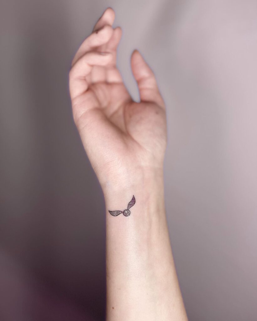 Cute and simple wrist tattoos with a harry potter golden snitch twist
