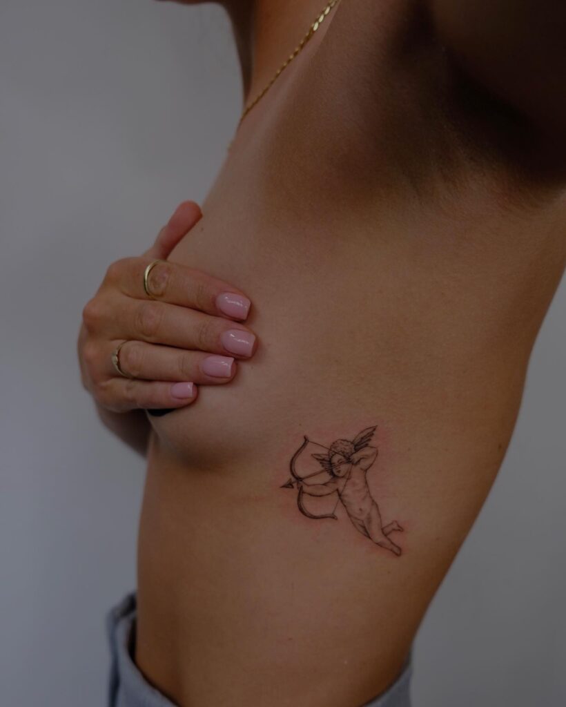 Cute angel with bow and arrow tattoo on the left side rib: cherubic archery