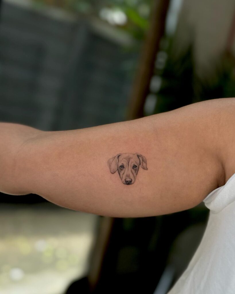 Cute pet portrait tattoo on the inner arm, a heartwarming black and grey tribute: Pet's embrace