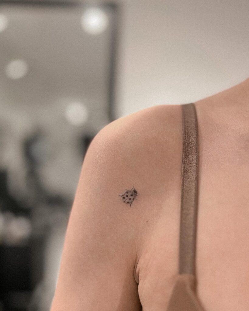 Dainty and delightful small arm and shoulder ladybug tattoo for girls