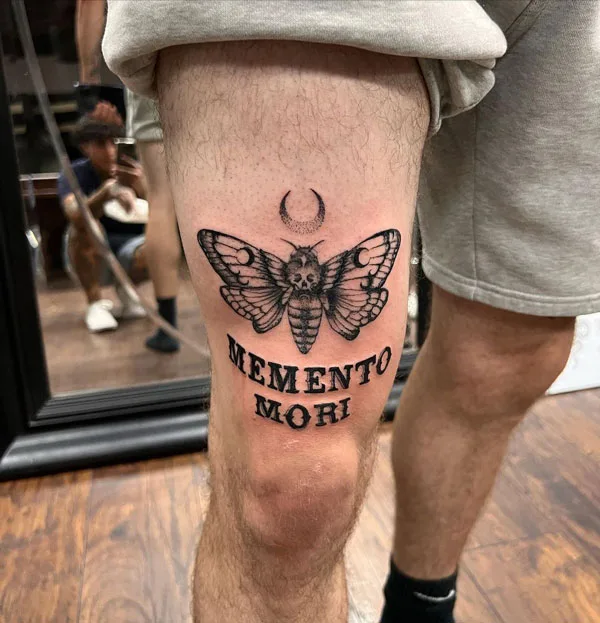 Death moth above knee tattoo