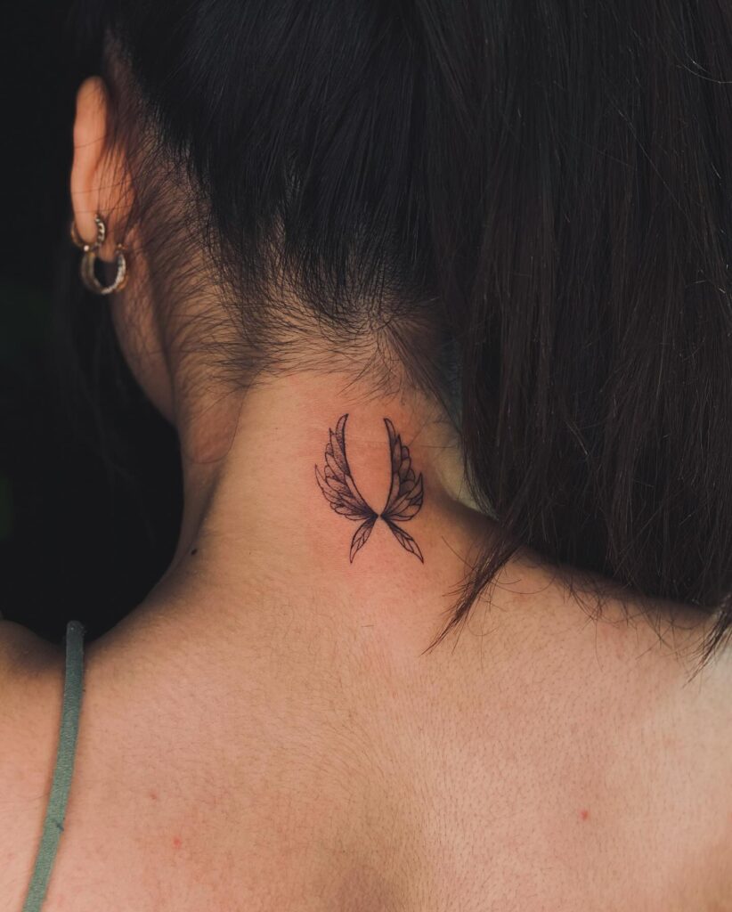 Delicate angel wings tattoo on the nape of the neck for remembrance