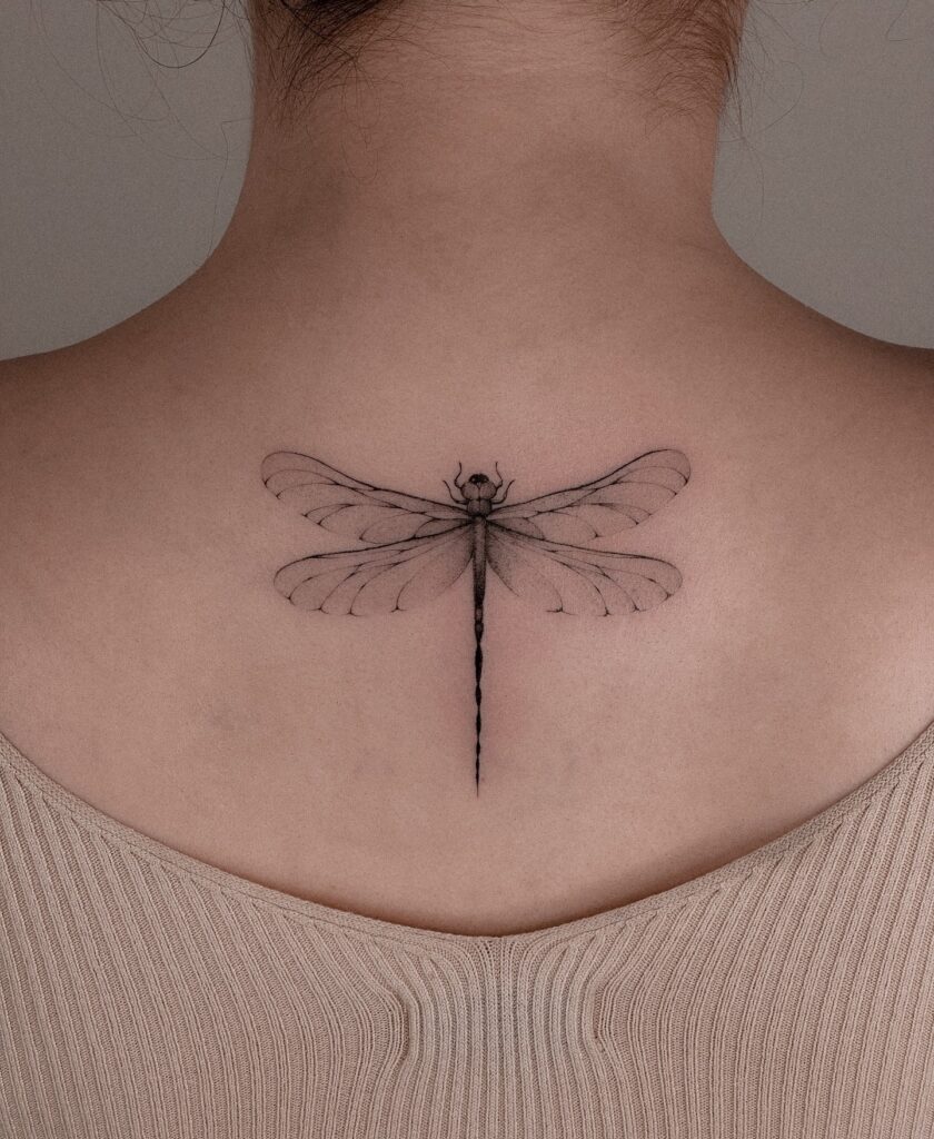 Delicate Fine-Line Dragonfly Upper Back Tattoo Symbolizing Freedom and Growth