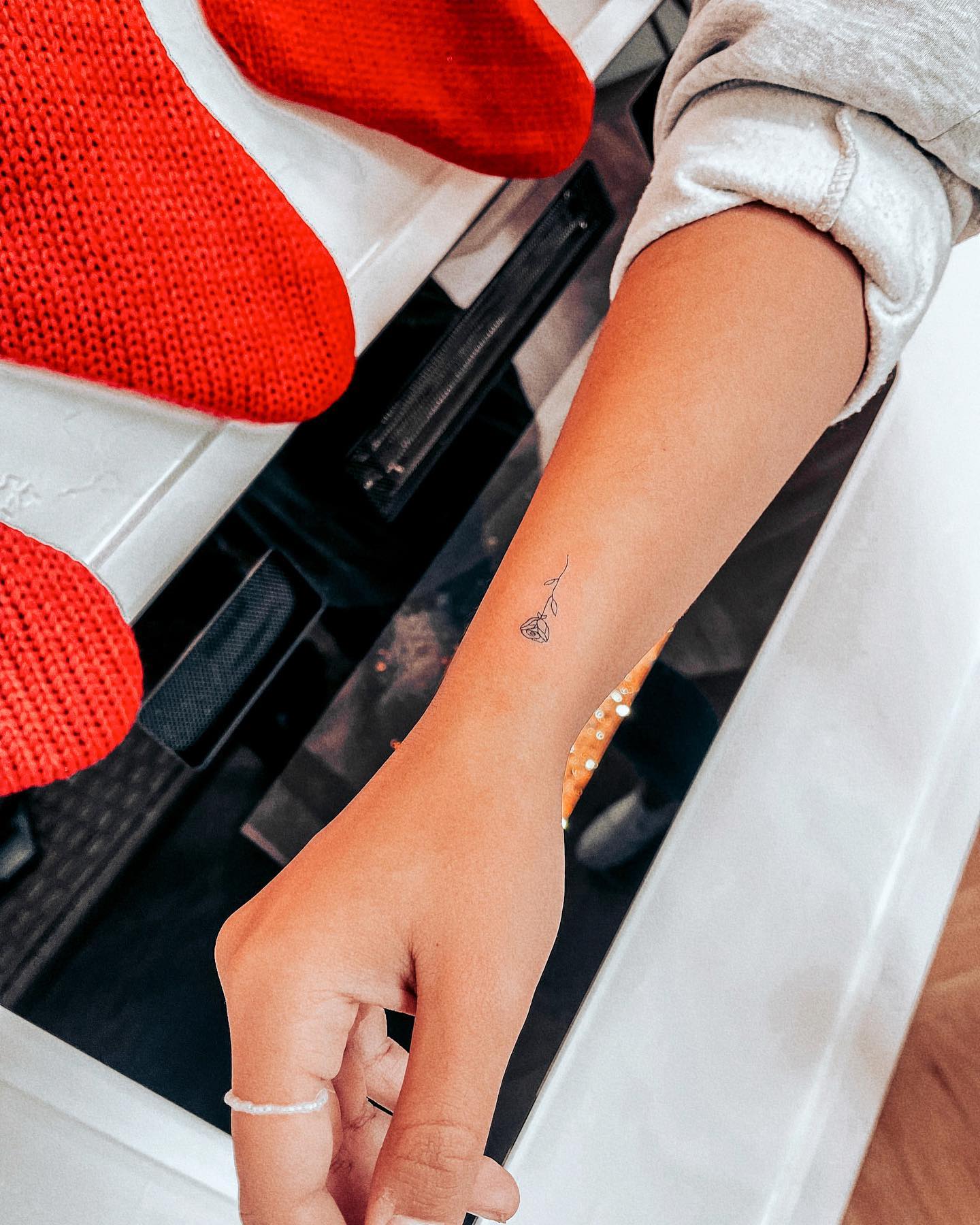 Delicate Hanging Rose Fine-Line Wrist Tattoo Elegant and Meaningful Design