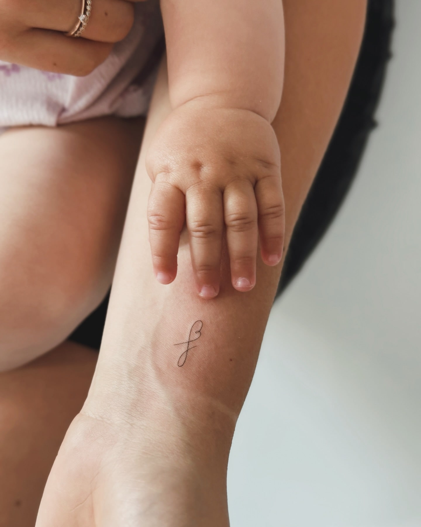 Delicate Script Letter 'F' Tattoo on Wrist Symbolizing Deep Personal Connection