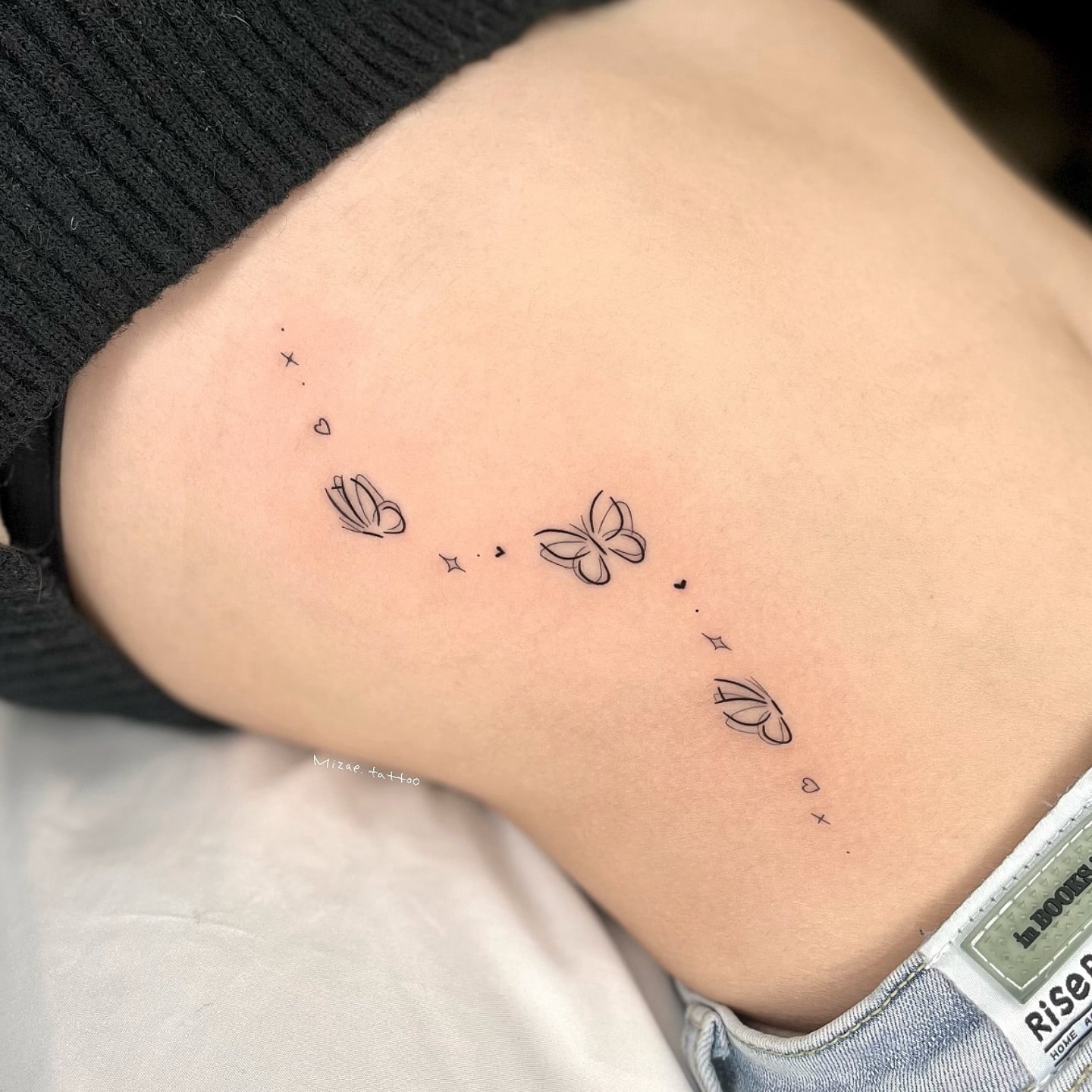 Delicate three butterflies tattoo on back with dot and star accents