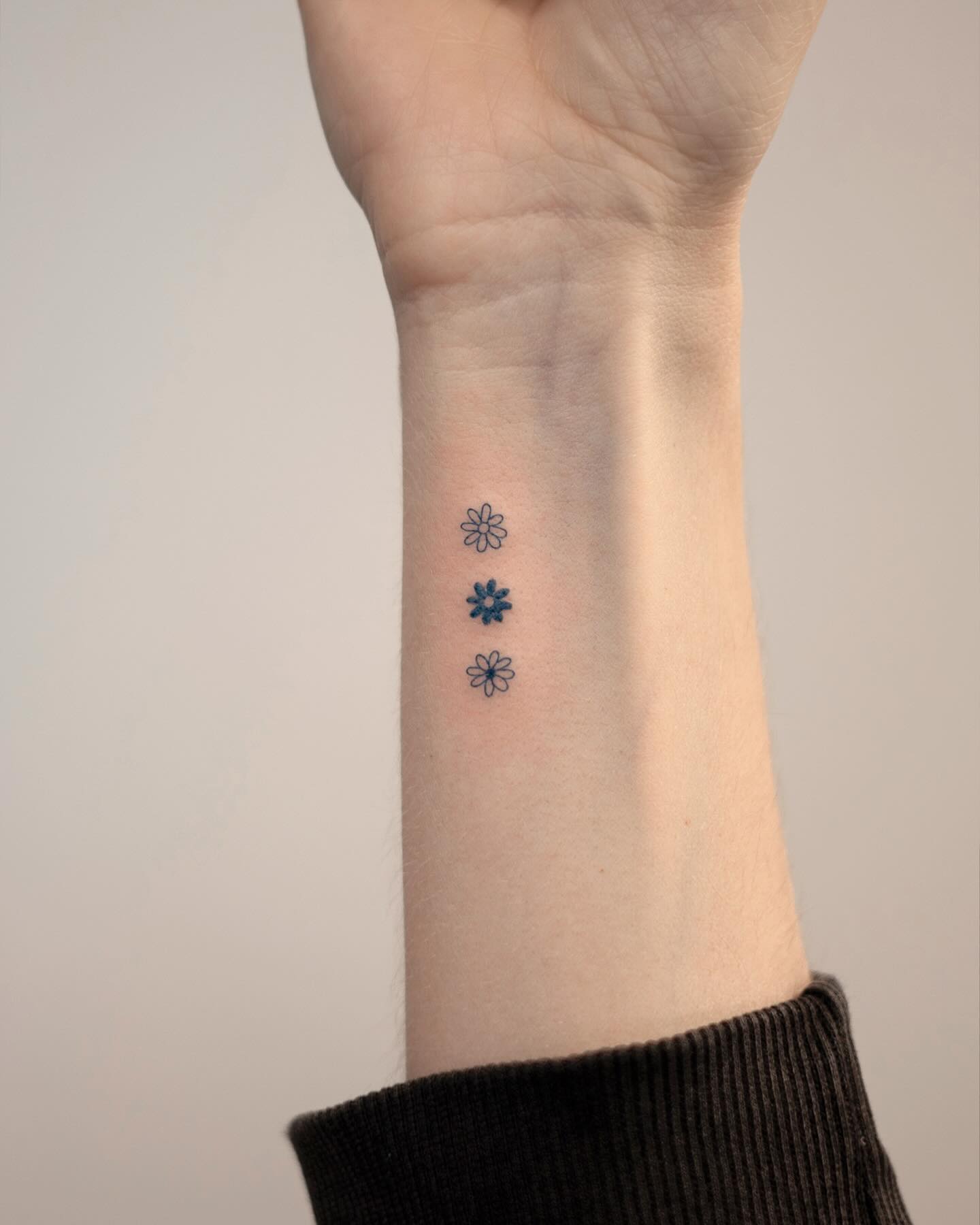 Delicate Trio of Flowers Wrist Tattoo Feminine and Elegant Tiny Floral Design