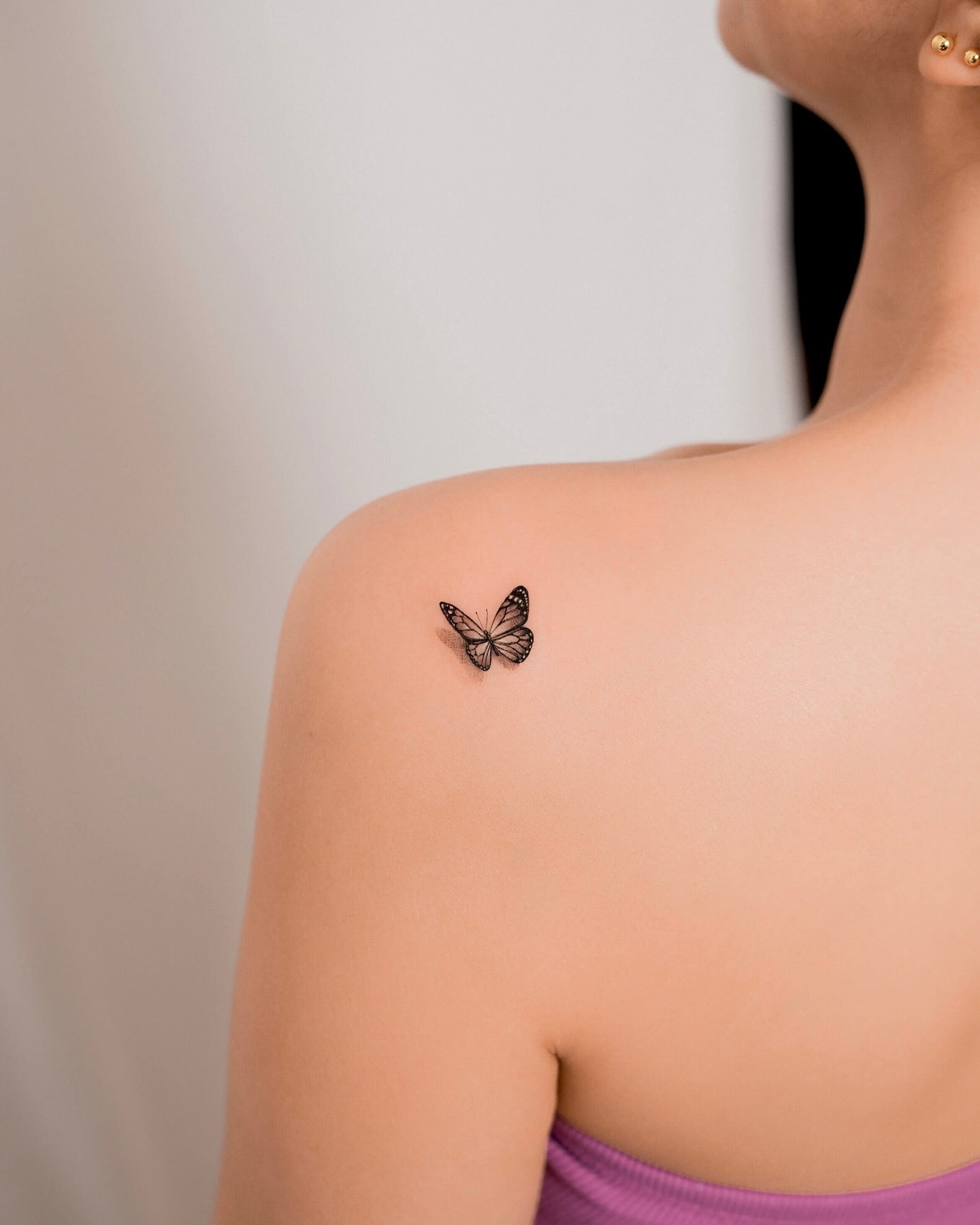 Detailed butterfly shoulder blade tattoo with realistic wing patterns