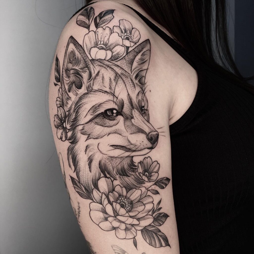 Detailed side view fox face surrounded by flowers on the upper arm blooming whiskers