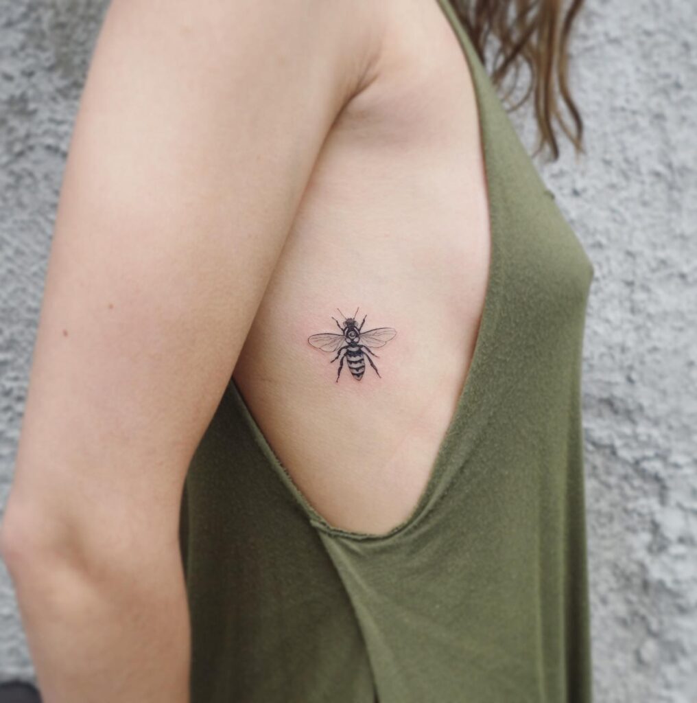 Detailed small bee tattoo on the rib tiny and intricate insect inspired ink