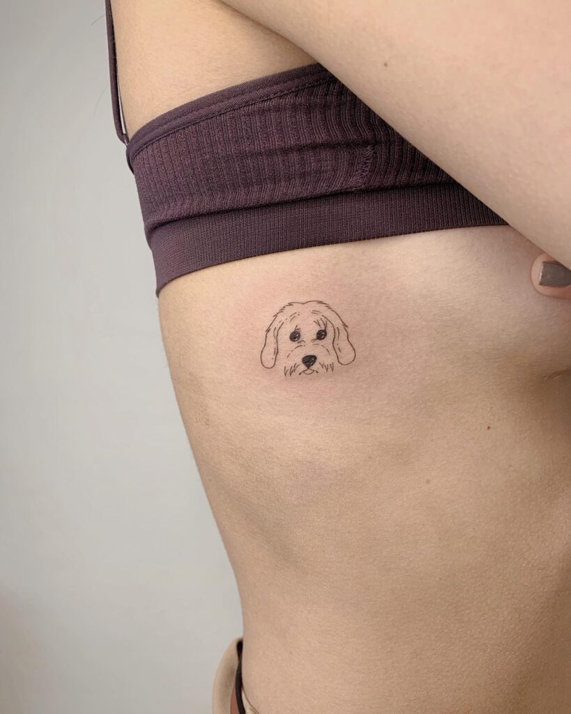 Dog portrait face tattoo on the rib: pawprints of love