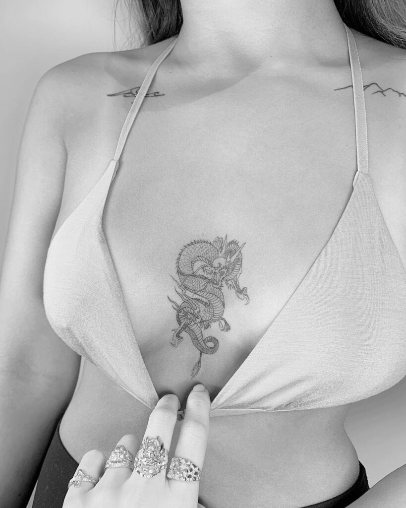 Dragon sternum tattoo with flowing linework symbolizing power and wisdom