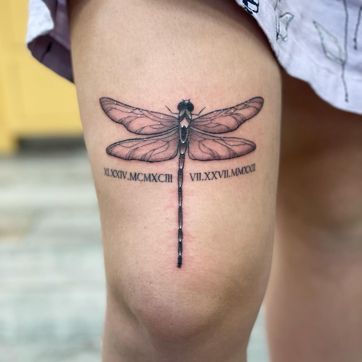 Dragonfly Above Knee Tattoo Design With Roman Numerals
