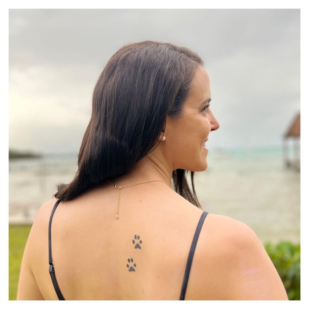Duo of delight two small filled paw prints back tattoo for women