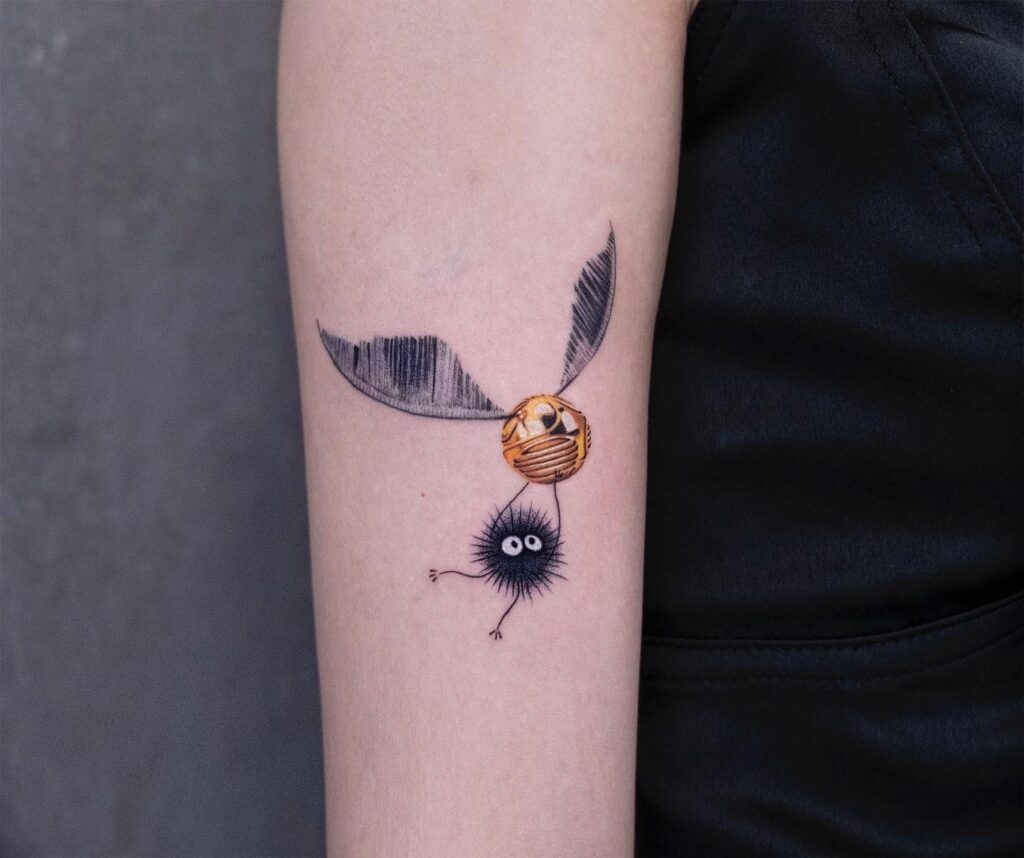 Dust bunny lifting dreams golden snitch tattoo on the forearm