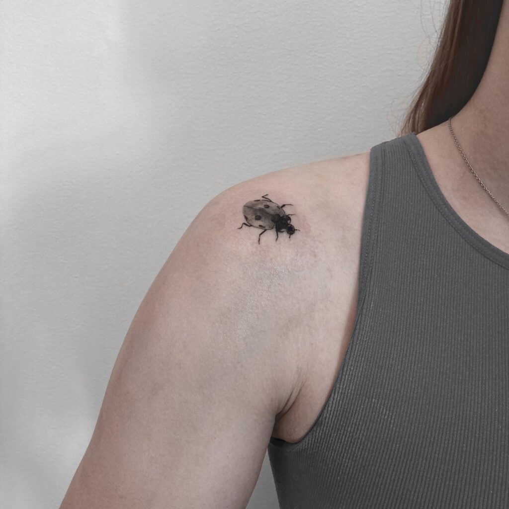 Elegant Black and Grey Ladybug Shoulder Tattoo for Women Timeless Beauty with a Delicate Touch