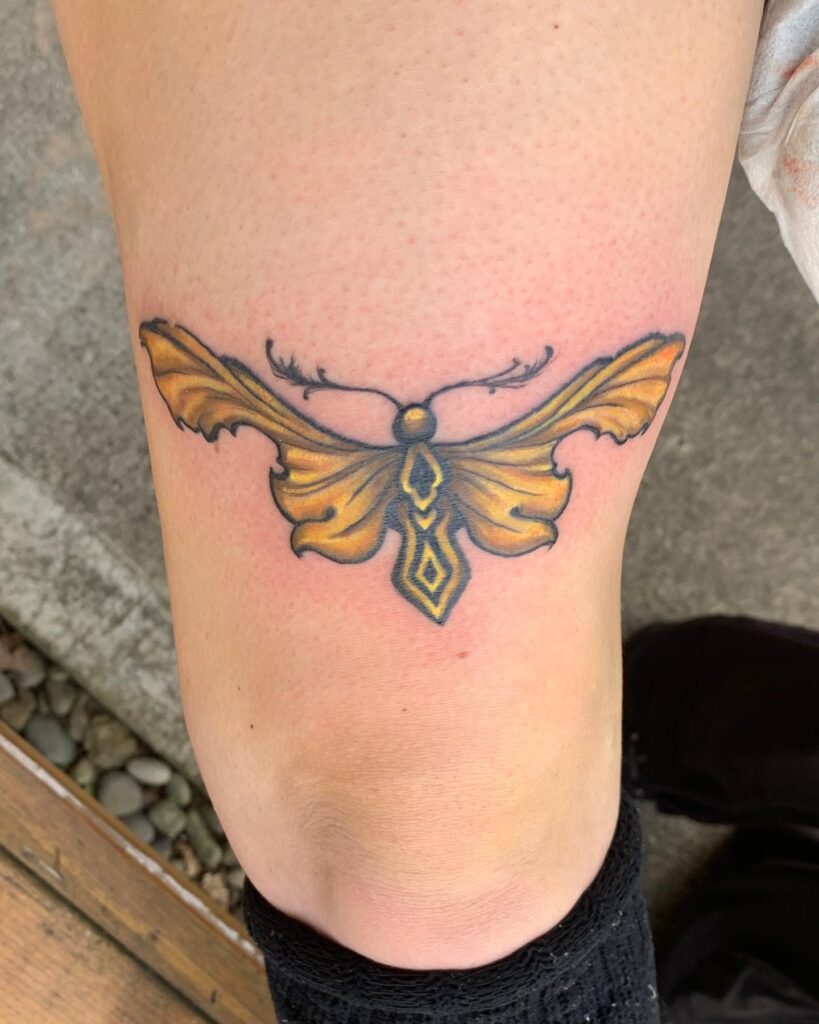 Elegant and Minimalist Simple Golden Moth Tattoo Above Knee