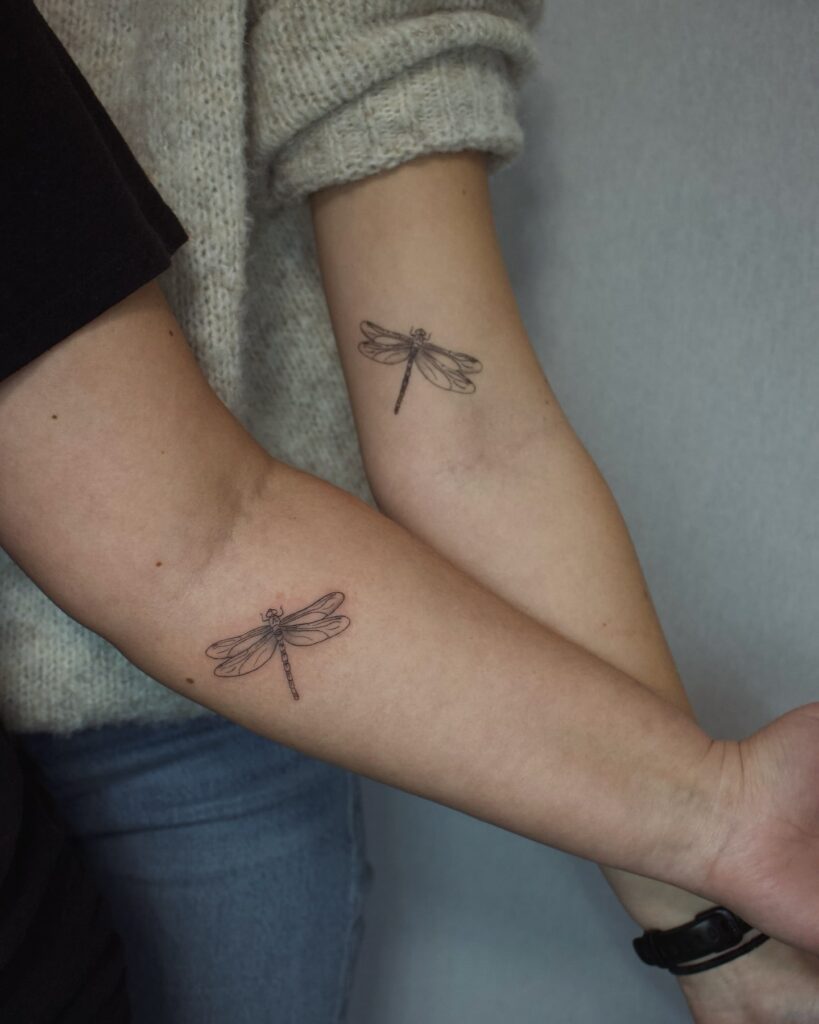 Elegant dragonfly forearm tattoo for strength and transformation in mother-daughter relationships