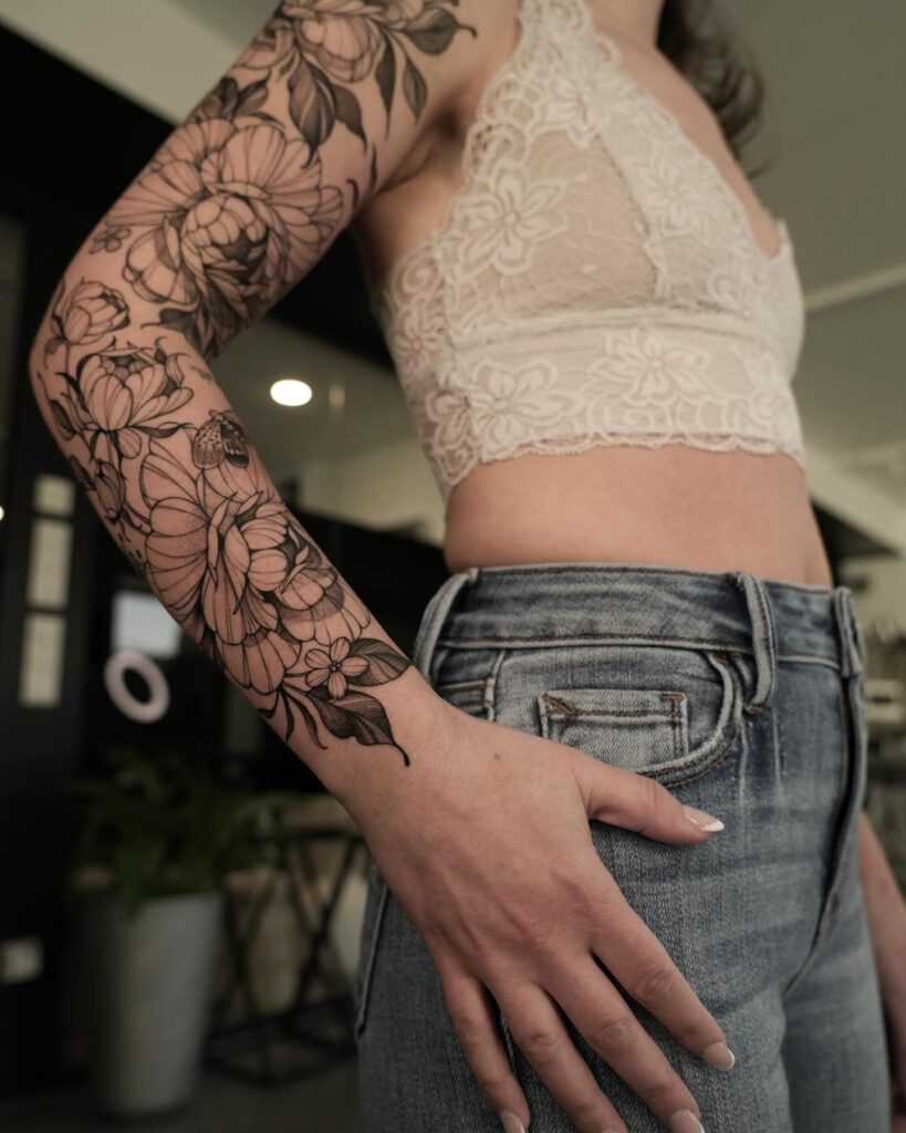 Elegant feminine floral sleeve tattoo with intricate fine-line and dotwork shading
