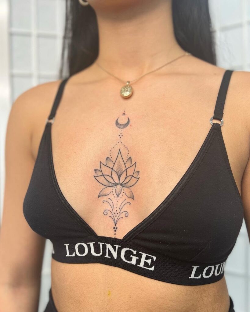 Elegant lotus and crescent moon sternum tattoo with spiritual symbolism