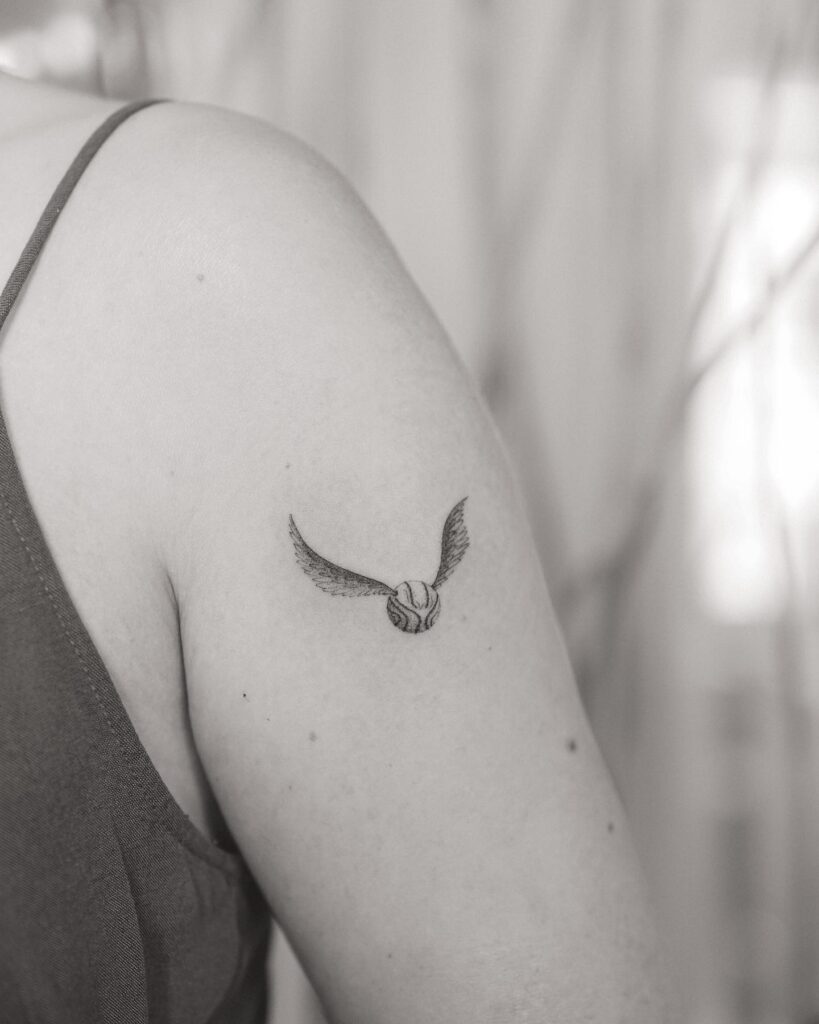 Elegant simplicity upper arm golden snitch tattoo ideas for women