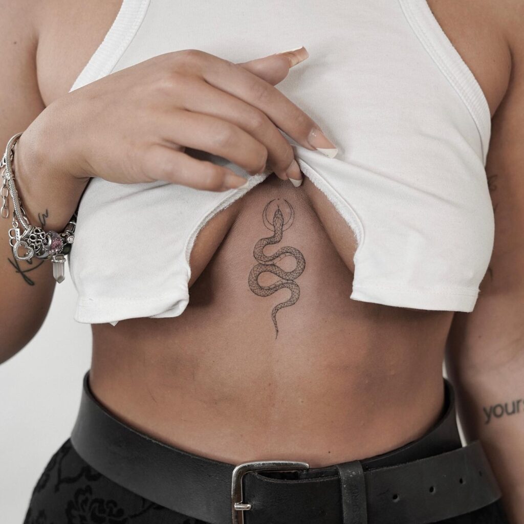 Elegant snake sternum tattoo with illuminating aura symbolism