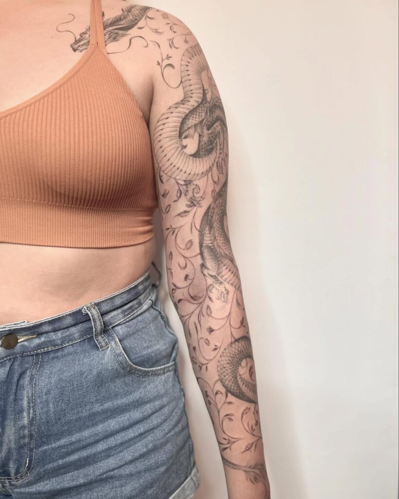 Elegant snake tattoo sleeve with fine-line ornamental details for women
