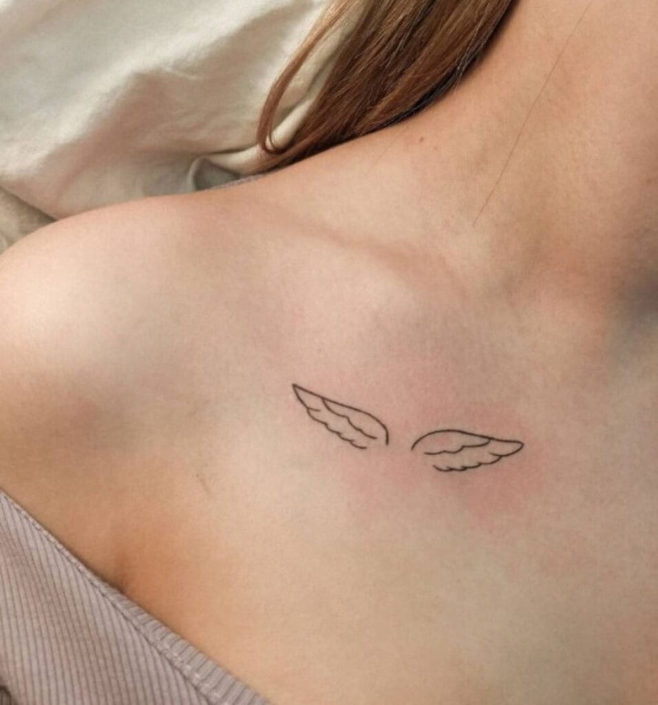 Elegant wing tattoo adorning the collarbone, a subtle celestial grace angelic elegance