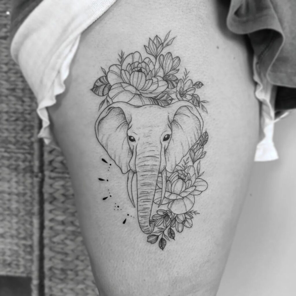 Elephant head with flowers, a women's side tattoo: floral grace on the thigh