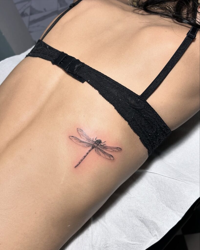 Ethereal Fine-Line Dragonfly Tattoo with Elegant Rib Placement