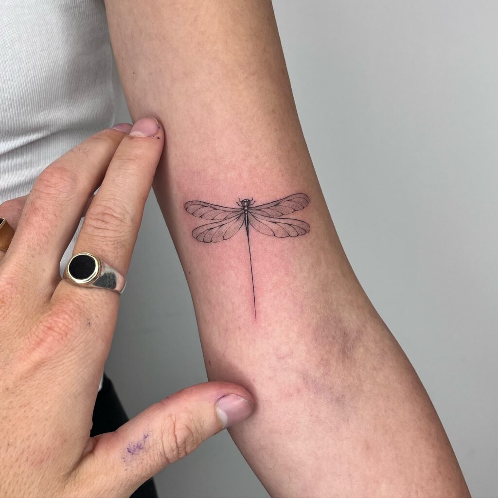 Ethereal Minimalist Dragonfly Tattoo with Subtle Fine-Line Details