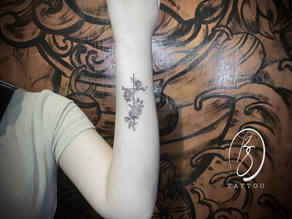 Eye-Catching Outer Forearm Tattoo Striking Cross with Roses