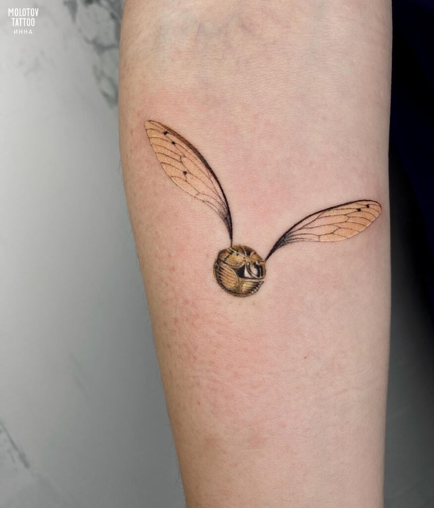 Eye catching tattoos below the inner elbow golden snitch edition