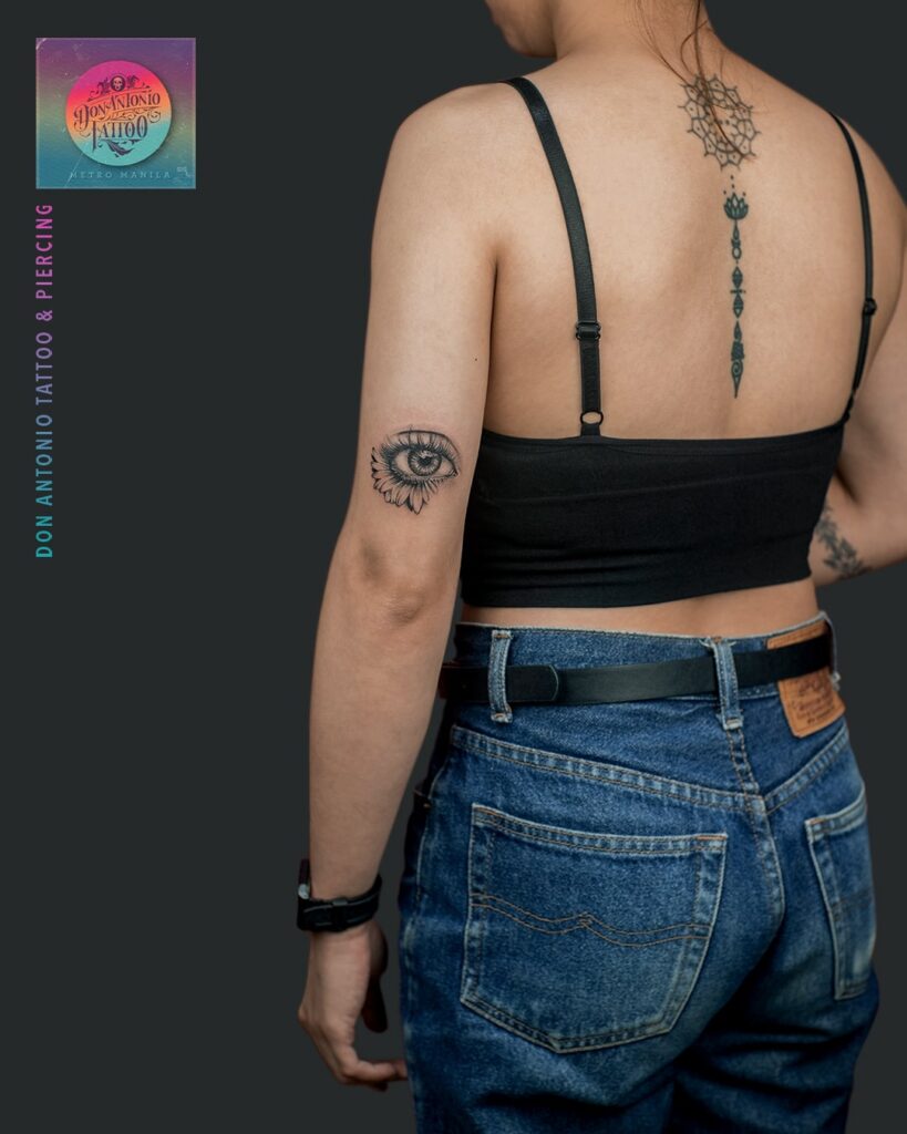 Eye tattoo with sunflower outline outer arm elegance for women