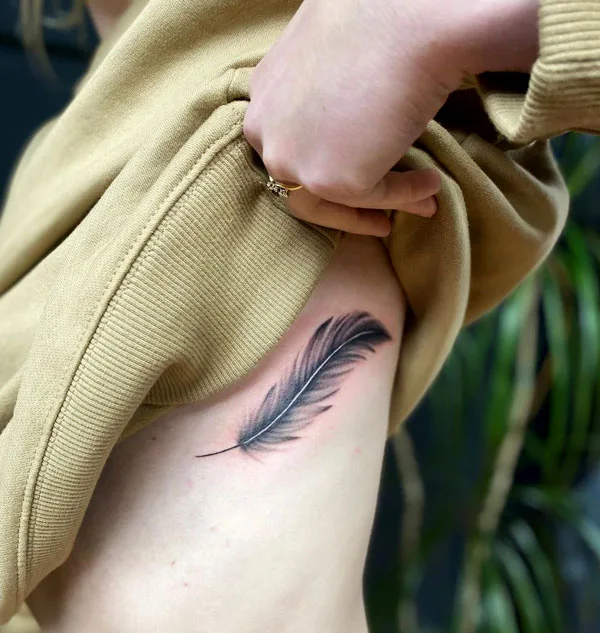 Feather side boob tattoo